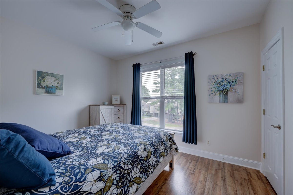Third bedroom with blue and white decor, hardwood floors and ceiling fan
